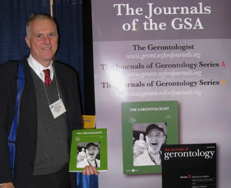 Dr. Jeff Levine showing one of his photographs in the cover of The Gerontologist